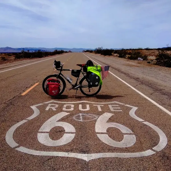 Tourman cycling on Route 66 desert road